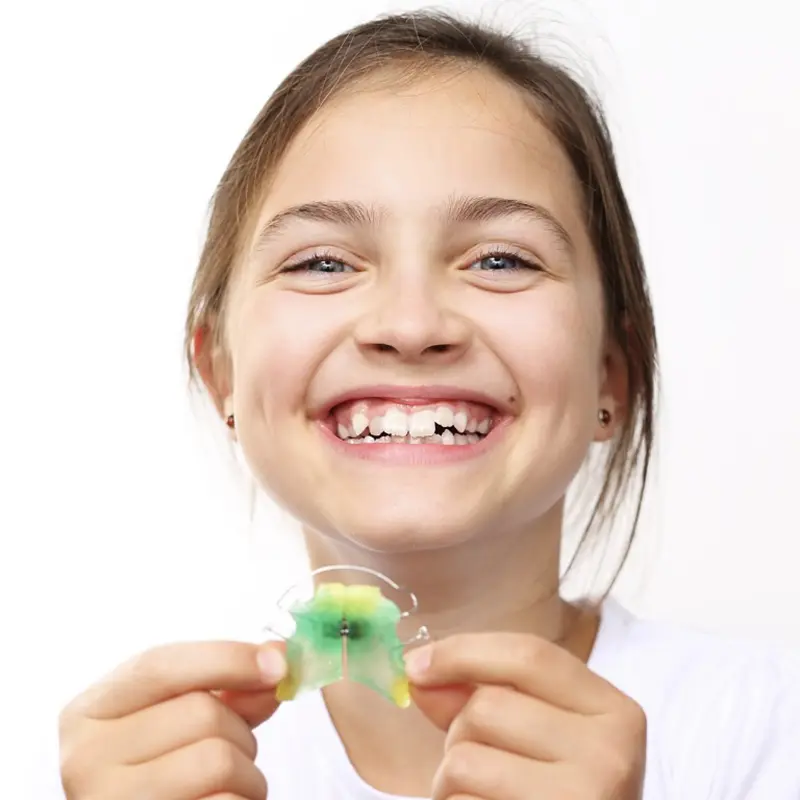 bambina sorridente con apparecchio dentale
