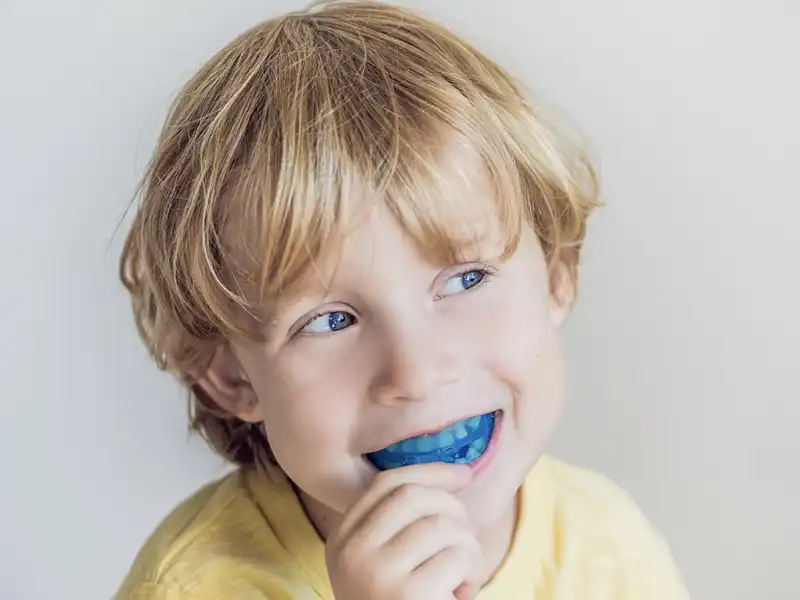 bambina gioca con apparecchio dentale