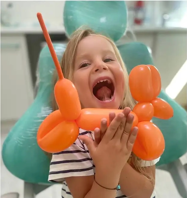bambina dal dentista gioca con palloncino per check-up odontoiatrico bambini